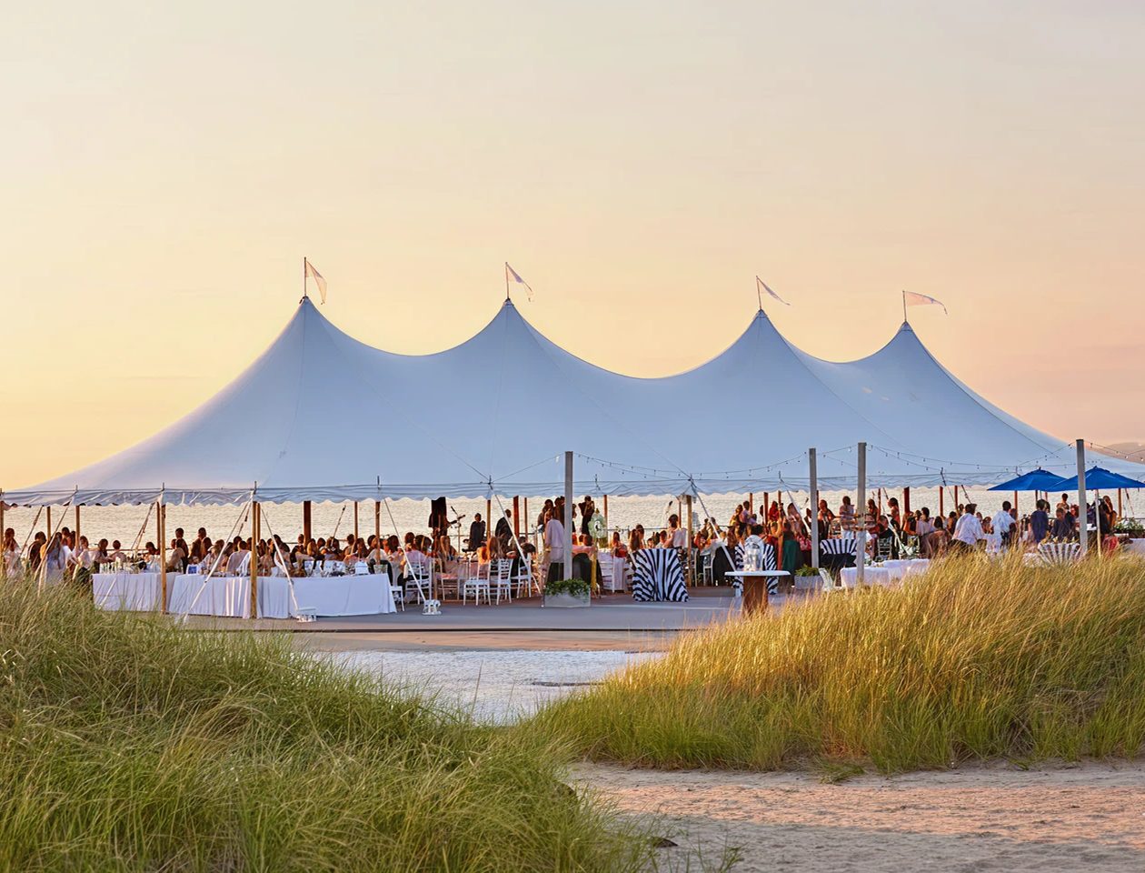 Large white stretch tent installed on a sandy beach for an outdoor event
